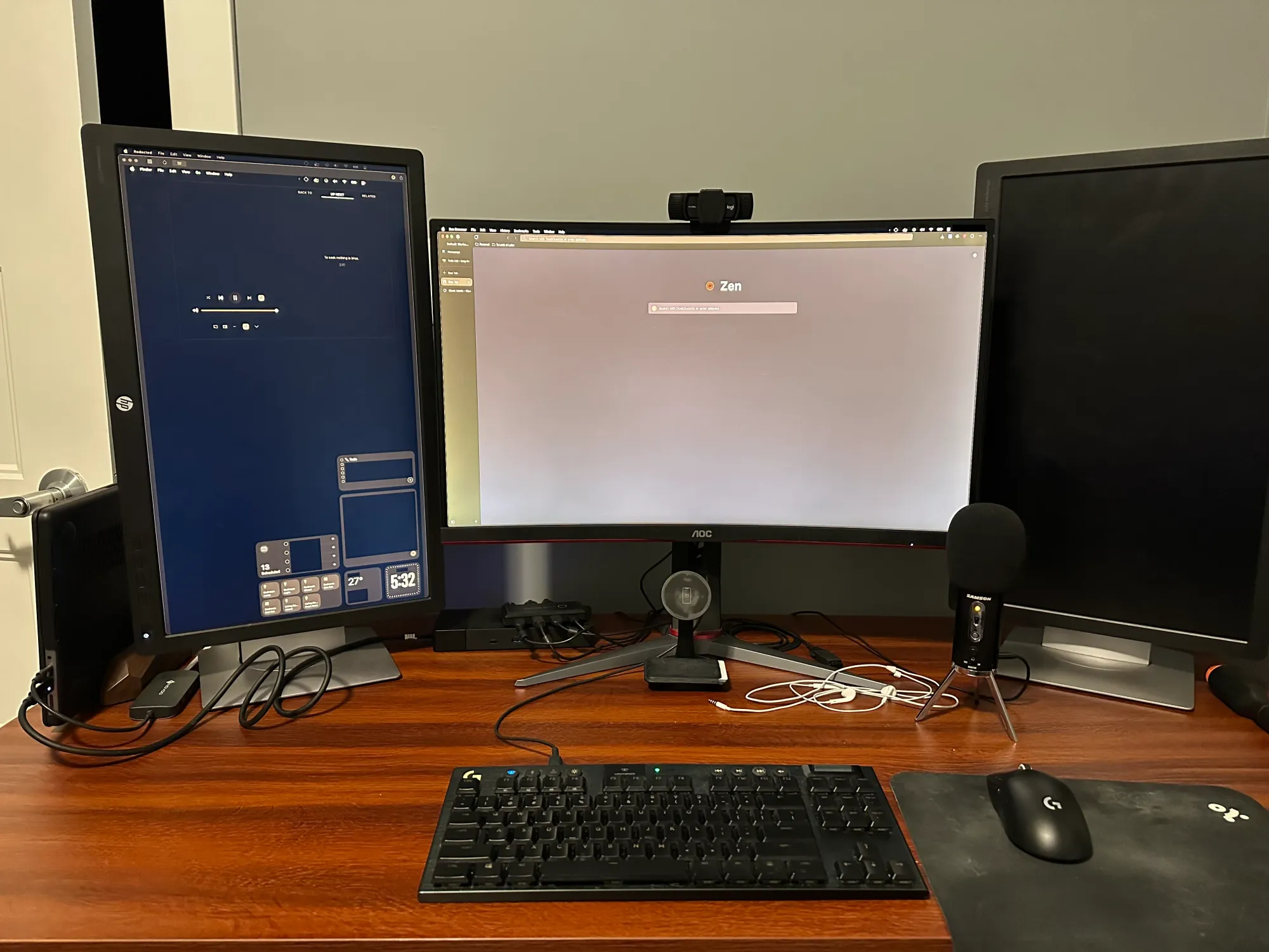 A photo of my desk with a keyboard, mouse, microphone, 3 monitors (2 vertical, 1 horizontal).